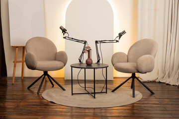 Cozy podcast studio setup with microphones, seating area, and decorative elements for engaging...