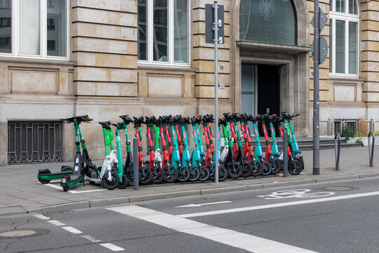 Frankfurt, Germany- April 18, 2025: Row of electric rental scooters from Bolt, Voi, and Lime rentable electric scooters parked along sidewalk, showcasing the city&rsquo;s modern micromobility options