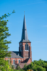 Saint John the Baptist catholic church with green surroundings in Huizingen, Flemish Brabant,...