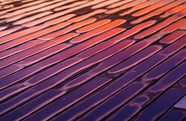 Charcos sobre la madera reflejando los colores del atardecer