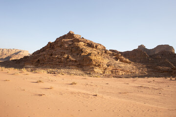 Rocky hillside against a clear blue sky. The sky is very bright, and the sun is shining. The desert is very hot for life, ecology, the heat is very high, there is no vegetation