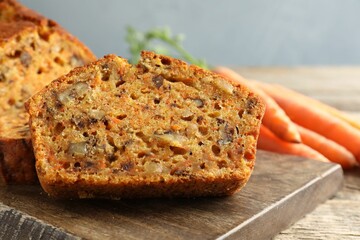 Homemade carrot cake with nuts and vegetables on wooden table, closeup