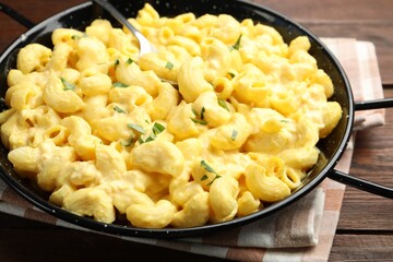 Delicious pasta with cheese sauce on wooden table, closeup