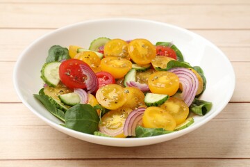 Fresh salad with yellow tomatoes on wooden table, closeup