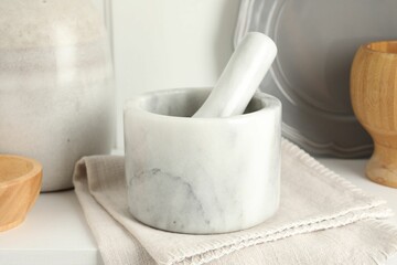 Marble mortar and pestle on white table indoors, closeup