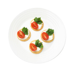 Tasty crackers with cream cheese, tomatoes and parsley isolated on white, top view