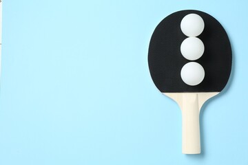 Ping pong racket and balls on light blue background, top view. Space for text