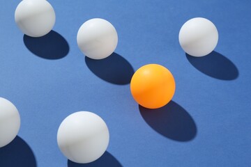 Many ping pong balls on blue background, closeup
