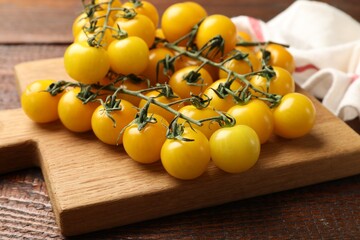 Ripe yellow cherry tomatoes on wooden table, closeup