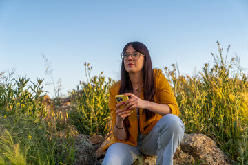 Young woman using smartphone in nature embracing minimalist lifestyle