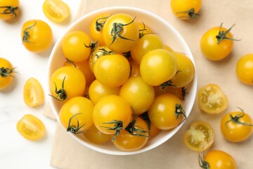 Many fresh yellow tomatoes on white table, flat lay