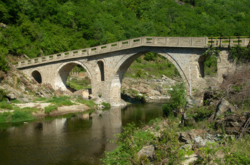 Medieval arched stone bridge Pilima over a river Kosynthos in the Rhodope Mountains in Greece