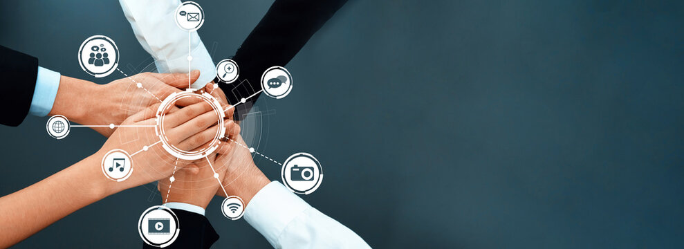 This image captures a powerful representation of teamwork, showcasing hands coming together in a collaborative effort symbolizing unity and digital connectivity in a modern business environment. Amity