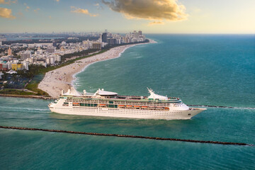 Cruise ship leaving Miami harbor main channel near South Beach. Luxurious hotels and apartment...
