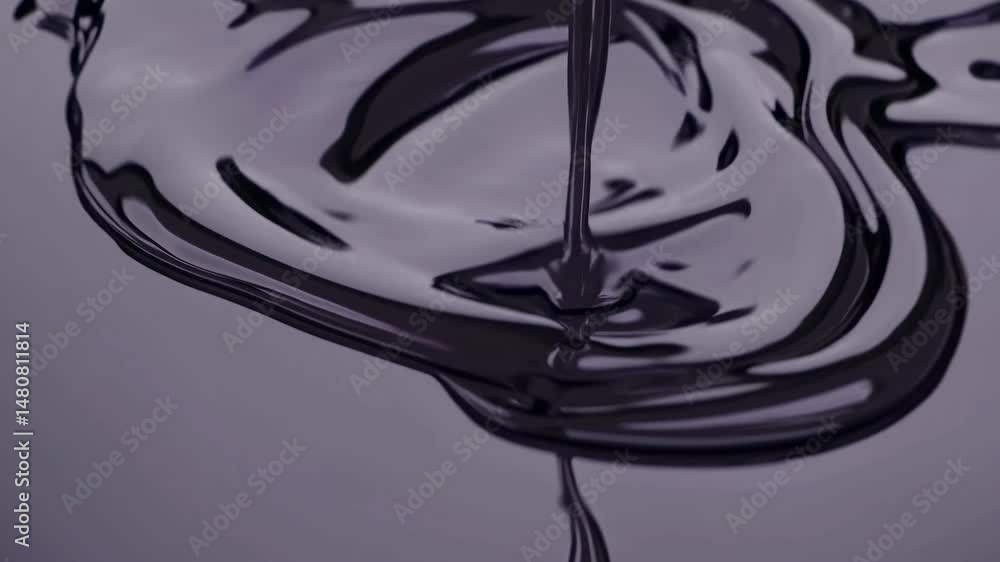 Poster thick, dark liquid pouring into a shallow pool of the same substance, creating mesmerizing circular 