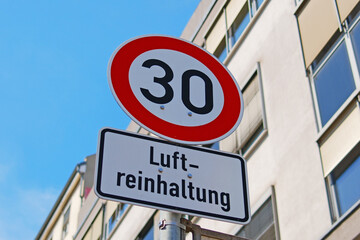 Tempolimit 30 zur Luftreinhaltung – Verkehrsschild in deutscher Stadt bei blauem Himmel