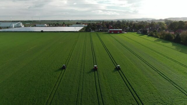 Drone Footage of Tractors Driving and Standing on Farmland &ndash; Aerial View of Agricultural Machinery in Action