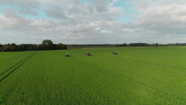 Drone Footage of Tractors Driving and Standing on Farmland &ndash; Aerial View of Agricultural Machinery in Action