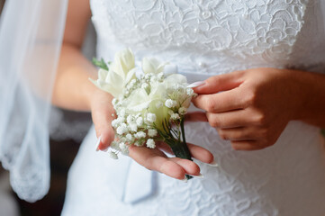 Bride Holding Delicate White Flowers on Wedding Day with Elegant Dress..