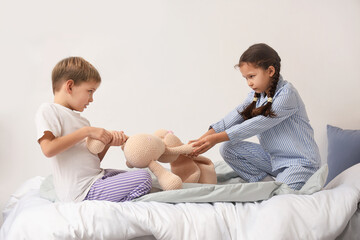 naughty little children taking toy from each other in bedroom