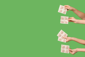 Female hands with mustard plasters on green background