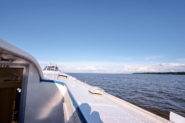 Calm Lake Horizon Viewed from Deck of Boat Under Clear Blue Sky..