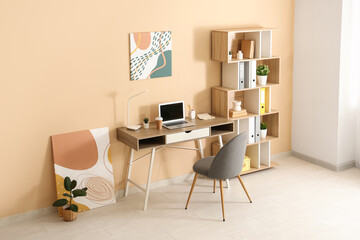 Interior of room with table, chair and shelving unit near beige wall