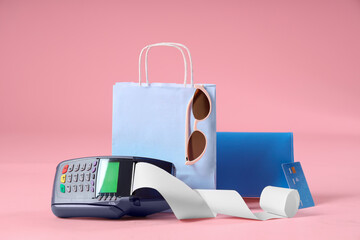 Blue shopping bag with stylish sunglasses, credit card and payment terminal on pink background