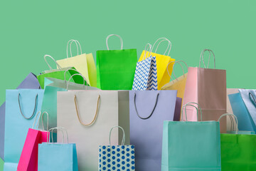Heap of different shopping bags on green background