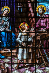 Fototapeta premium Stained glass (19th century) of Holy family: Jesus infant, Virgin Mary and St Joseph in the workshop of Joseph the carpenter.