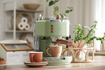Modern coffee machine and cups on kitchen counter