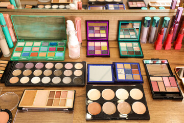 Various decorative cosmetics on makeup artist's table in studio, closeup