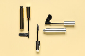 Black mascaras with smears on yellow background