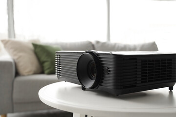 Modern projector on white table in living room, closeup