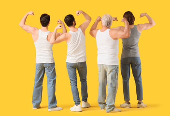 Fototapeta premium Group of men showing muscles on yellow background, back view. Body positive concept