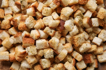 Many crunchy croutons on wooden background, closeup