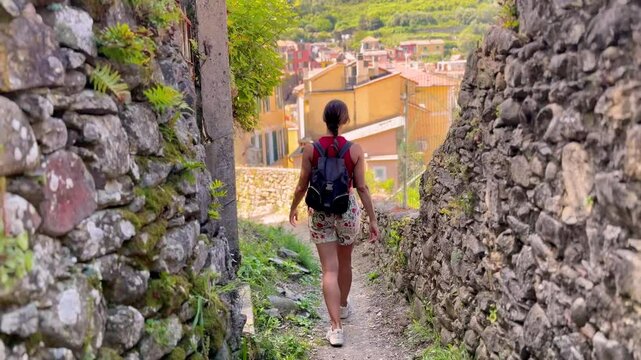 Young Woman Walking Through Picturesque Streets of Cinque Terre, Italy, Rear View in Colorful Mediterranean Village