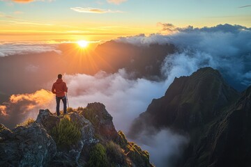Obraz premium Joyful Hiker on a Mountain Peak Embracing a Vivid Sunset Over Madeiran Landscape