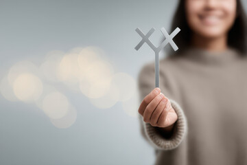 minimalist photograph of person holding symbol of hope for those with rare diseases against light background with