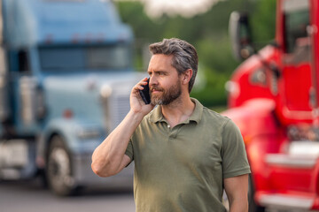 Plakat Man trucker driver at truck. Semi trucks vehicle. Hispanic man trucker. Mobile communication. Mature man driver truck talk on phone. Trucking owner. Truck driver has phone call. Logistical networking