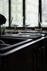 Clean wine glasses and decanter are on the table of a special wine cabinet, stylish table setting, ice, light from window, decoder and degasser