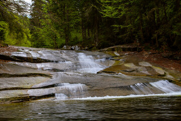 The wild mountain river Mumlava flows through rocky rapids. Mumlava Waterfall is located in the Czech Republic in the Mumlava Valley near Harrachov. Mountain resort in the Krkonoše Mountains. 