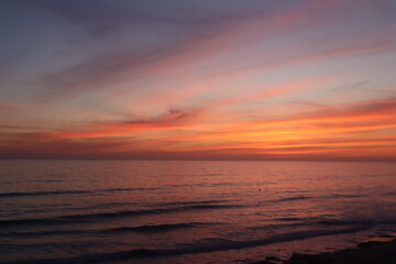 Beautiful pink bright colorful sunset in pacific beach san diego california with surfer silhouette