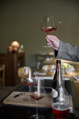 Champagne tasting in restaurant, A man holds in his hand a beautiful elegant glass with rose sparkling wine
