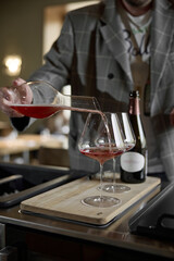 Champagne tasting, The sommelier pours sparkling wine from the decanter into a beautiful glass, Wine glasses are on the table, stylish table setting, sparkling wine bubbles
