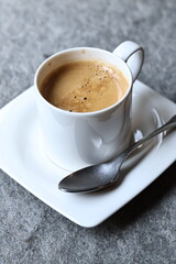 White ceramic coffee cup with hot morning coffee and biscuits on a rustic wooden table. A cozy breakfast scene filled with warmth, aroma, and the charm of a simple daily ritual.