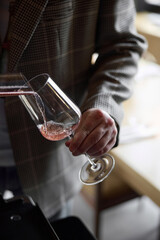 Champagne tasting, The sommelier pours sparkling wine from the decanter into a beautiful glass,...