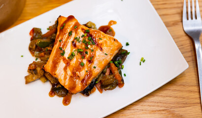 Baked salmon served with vegetable and teriyaki sauce on plate