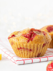 Homemade strawberry lemon muffin on kitchen table with white background. Close-up. Copy space.