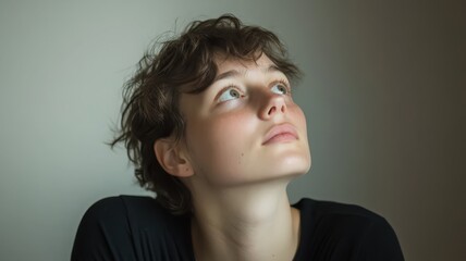 Portrait of a Young Woman Looking Upward in a Softly Lit Minimalist Setting